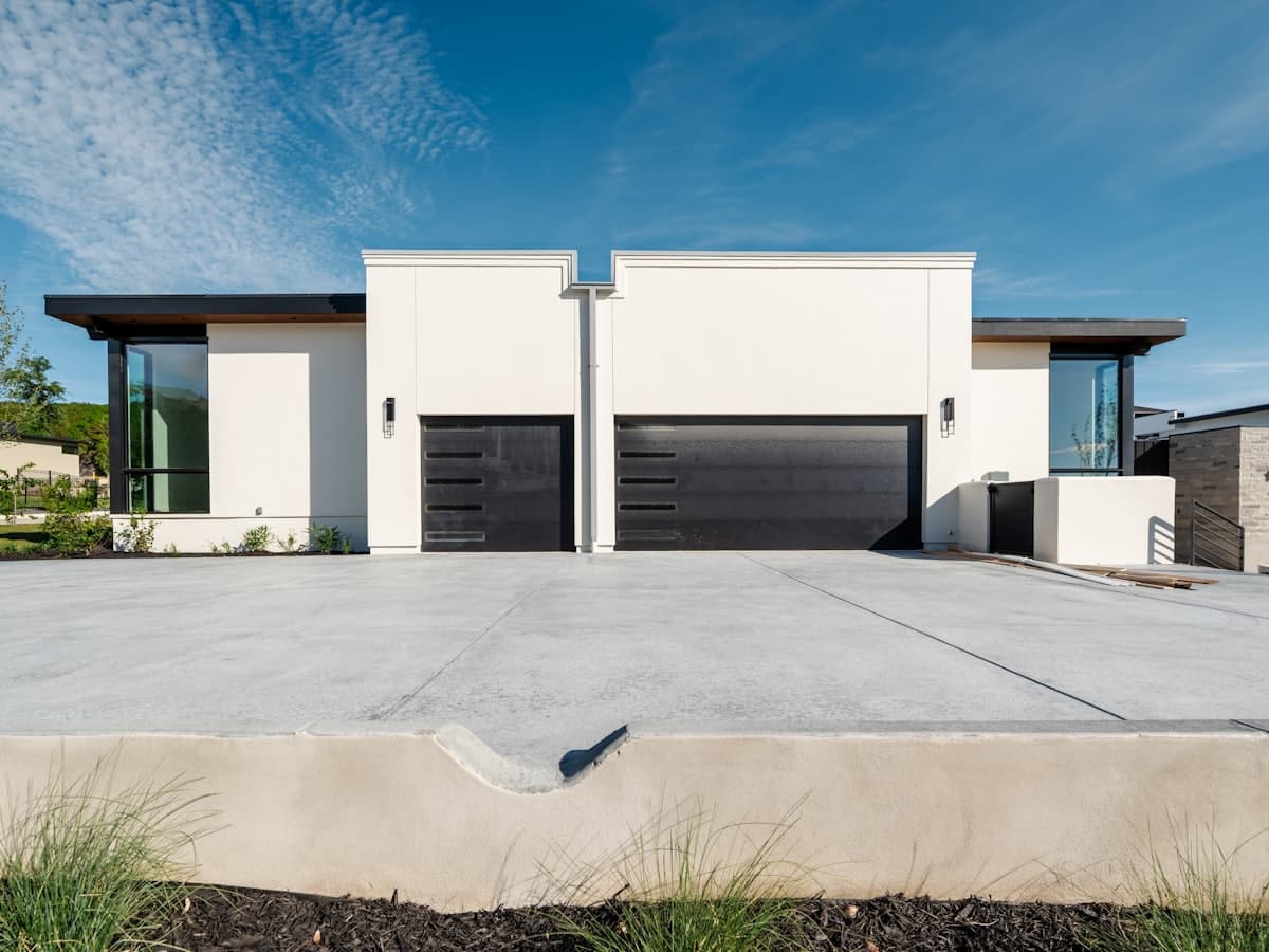 A wide concrete driveway running up to the garage of a modern home